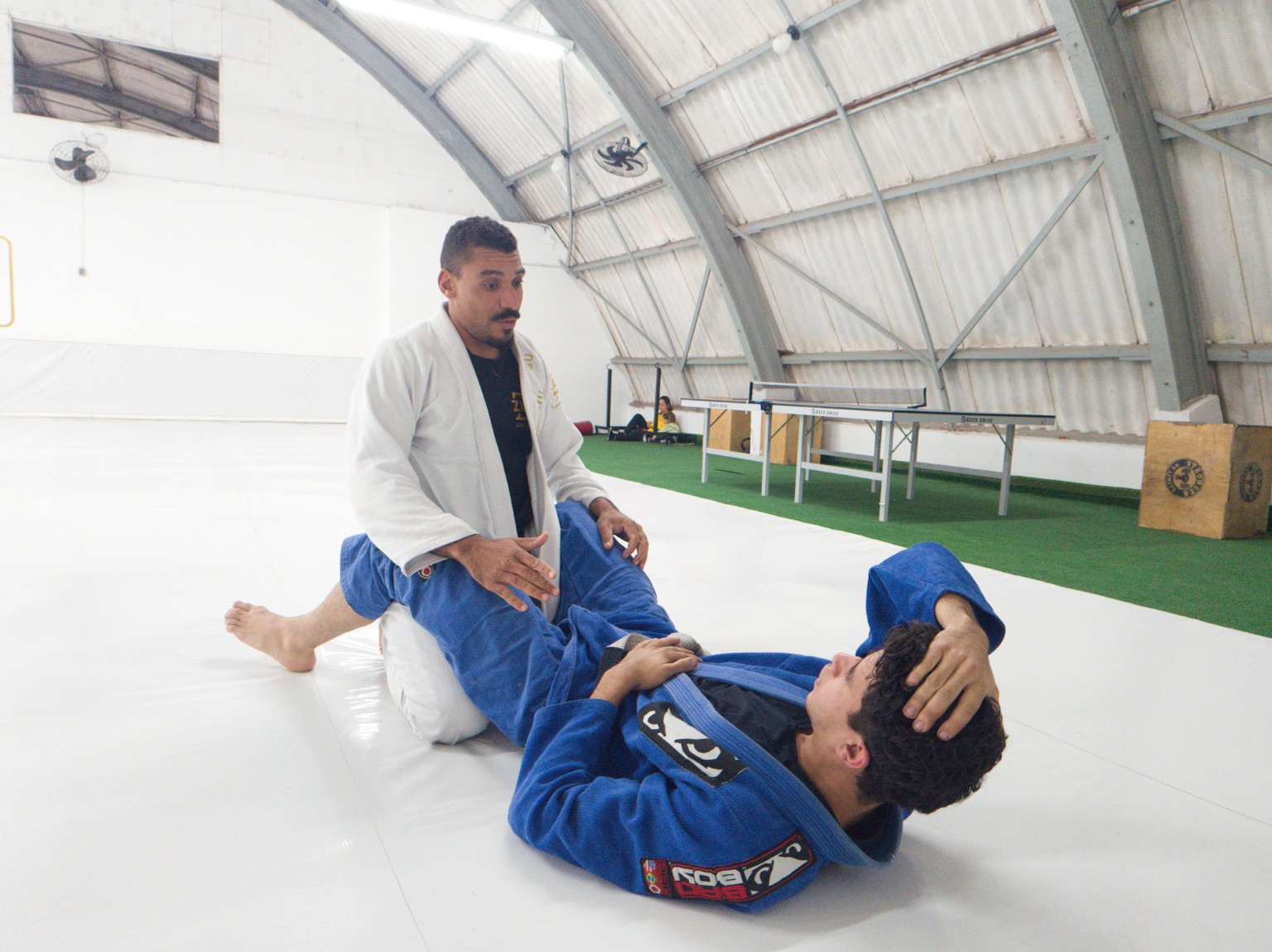 Professor orientando aluno durante treino de jiu-jitsu na unidade Guarapiranga